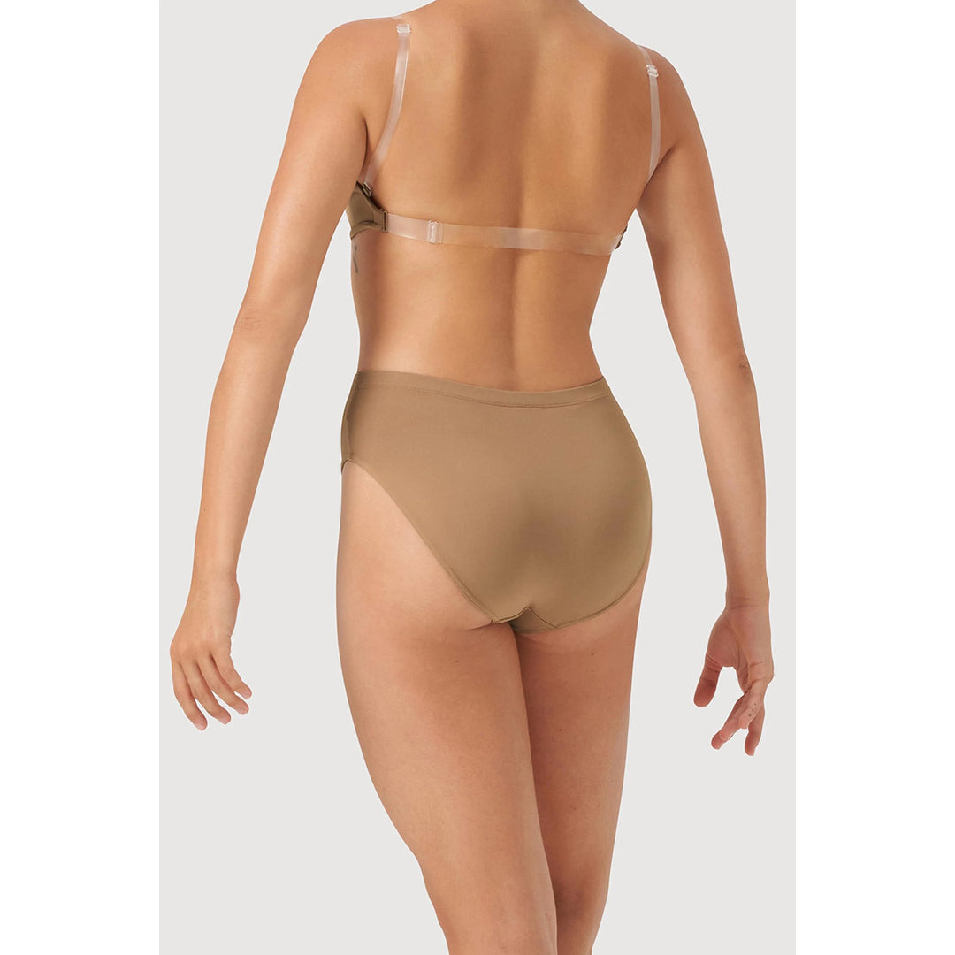 Rear view of a model wearing a sheer nude shapewear brief and matching underwire bra against a light gray studio background.