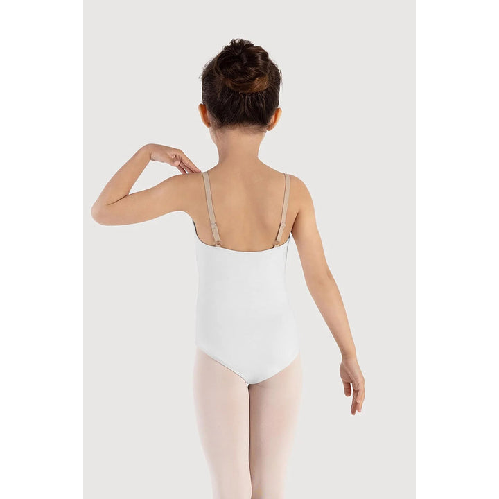 A child model shown from the back wearing a white ballet leotard with thin beige shoulder straps and matching white tights, set against a plain light gray studio background.