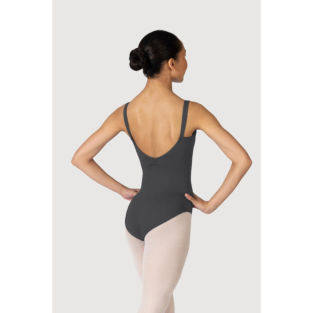 A woman modeling a dark gray ballet leotard from the back, paired with light pink tights, set against a solid light gray background.