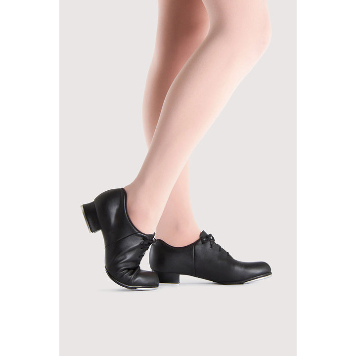 Black leather dance shoes with low block heels and lace-up fronts, shown on a model&