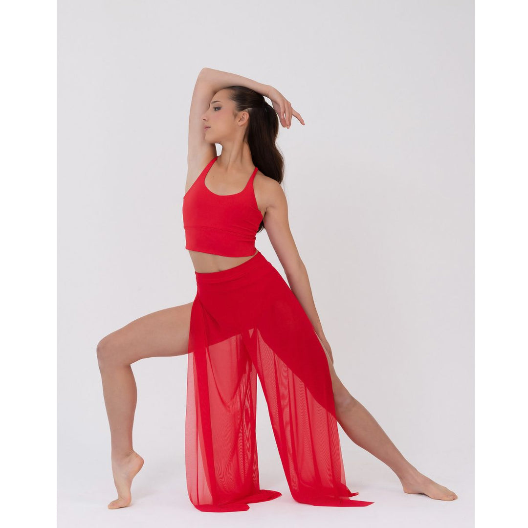 A woman modeling a bright red two-piece dance or yoga outfit consisting of a halter crop top and matching sheer wide-leg pants, posed against a light gray studio background.